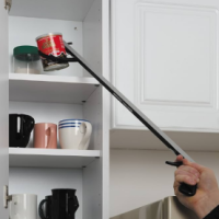 Man uses reacher to get item off the top of a kitchen shelf.